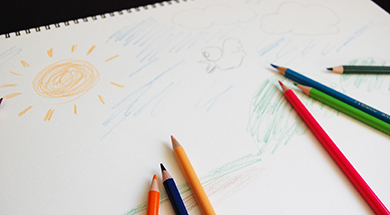 写真：画用紙に色鉛筆で絵を描いているところ